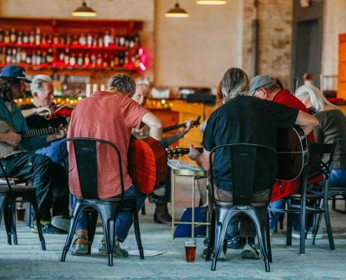 A group of musicians participate in a local jam with a variety of instruments. Image courtesy of Trailside Brewing